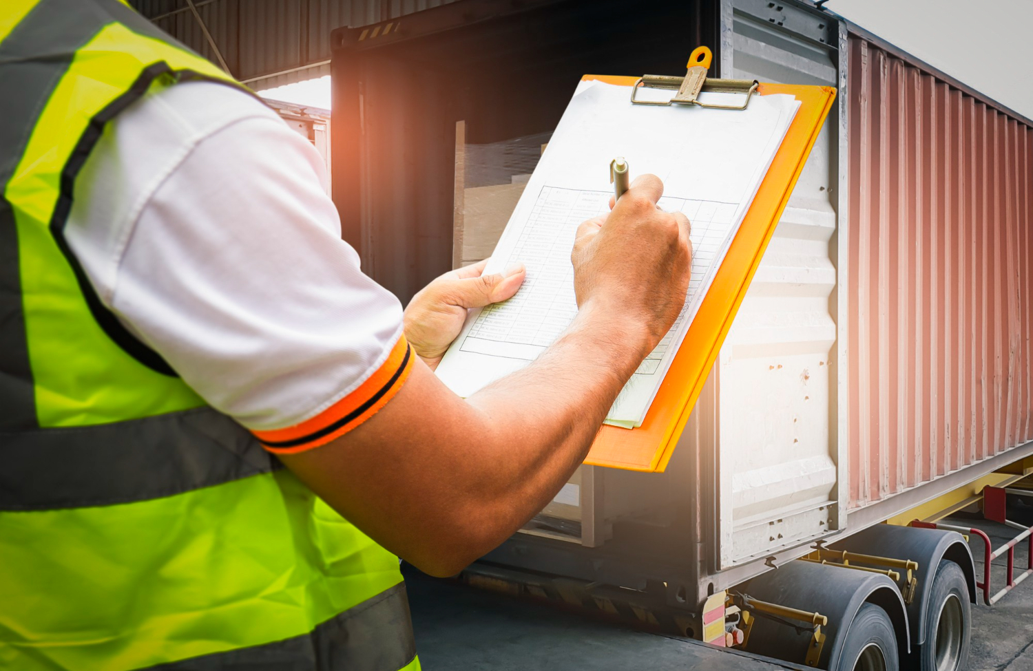 warehouse-worker-holding-clipboard-his-control-loading-cargo-boxes-into-shipping-container